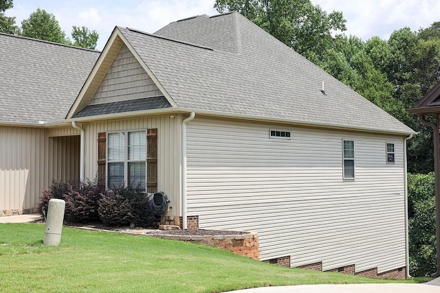 view of side of property with a yard, a shingled roof, and crawl space