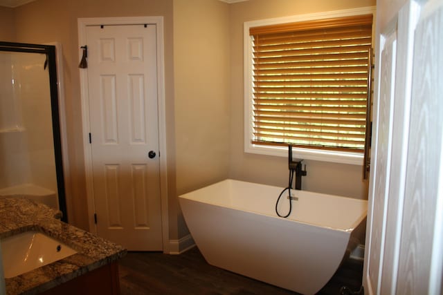 bathroom featuring a shower, a freestanding tub, vanity, and wood finished floors