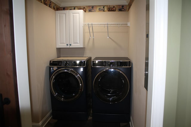 laundry room with cabinet space, baseboards, ornamental molding, and washer and clothes dryer