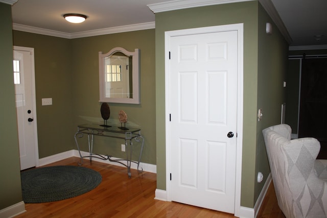 foyer entrance with wood finished floors and crown molding