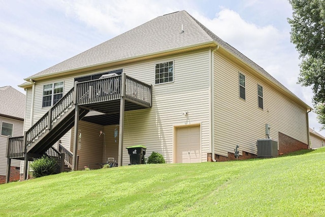 rear view of house with a shingled roof, central AC, a lawn, and stairway