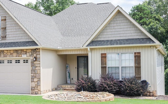 view of front of house with stone siding, roof with shingles, and an attached garage