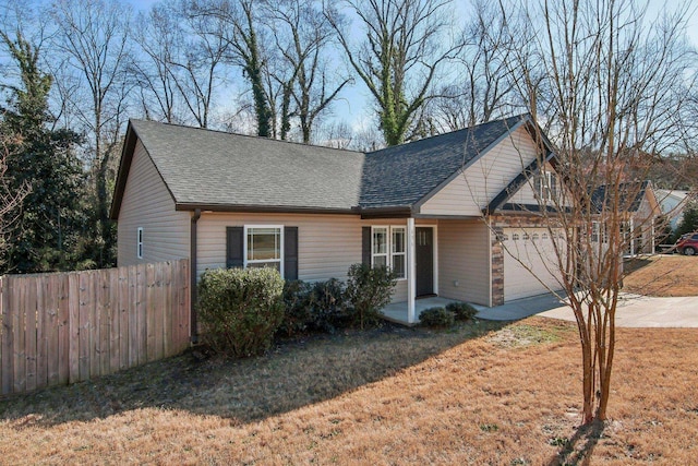 view of front of property featuring a shingled roof, fence, driveway, and an attached garage