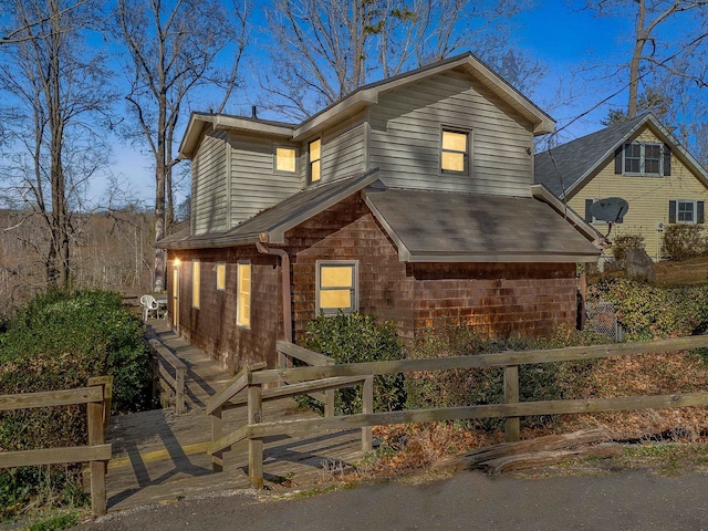 view of front of house featuring a fenced front yard and roof with shingles