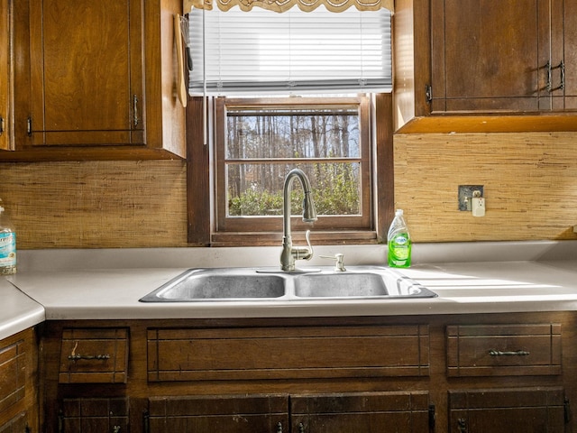 kitchen featuring light countertops, a sink, and wooden walls