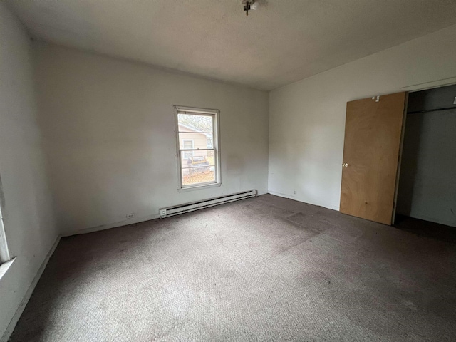 unfurnished bedroom with a baseboard radiator, a closet, and carpet