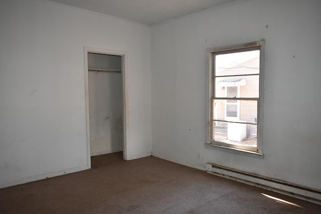 unfurnished bedroom featuring carpet, baseboard heating, and a closet