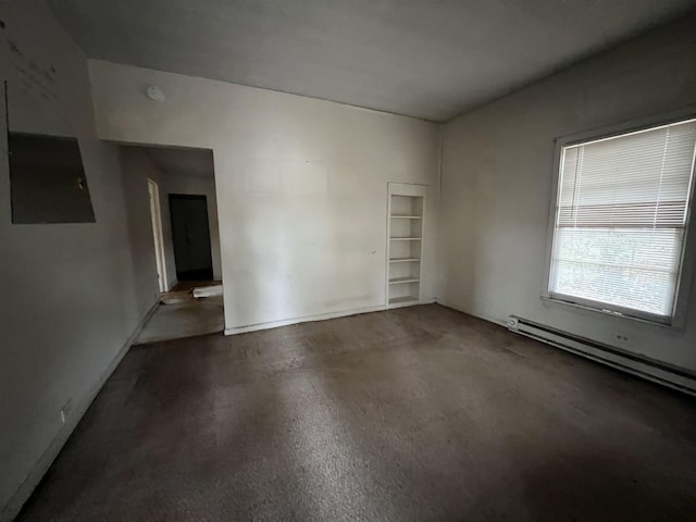 spare room with a baseboard radiator, electric panel, and finished concrete flooring