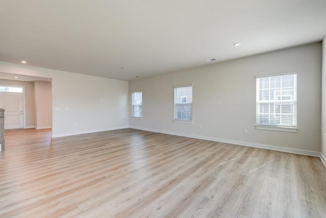 empty room with recessed lighting, light wood-type flooring, visible vents, and baseboards