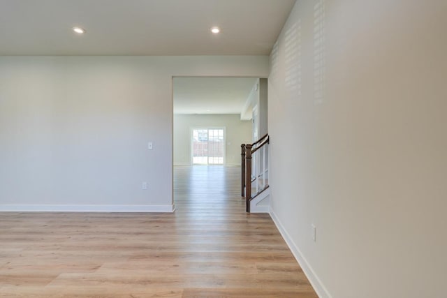 spare room featuring light wood-style flooring, recessed lighting, stairway, and baseboards