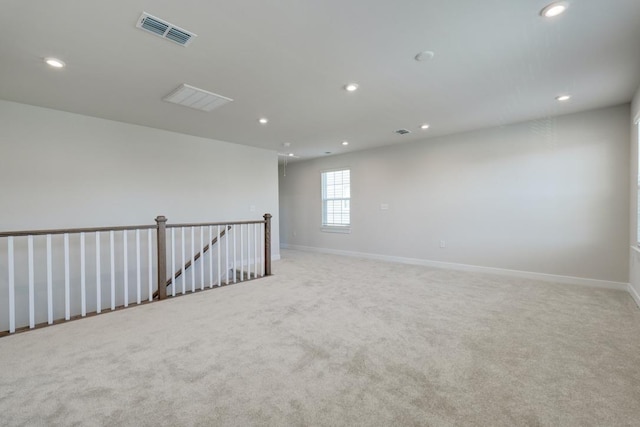 empty room featuring light colored carpet, recessed lighting, visible vents, and baseboards