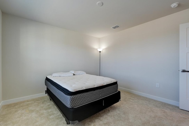 bedroom with baseboards, visible vents, and light colored carpet