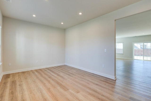 empty room with recessed lighting, light wood-type flooring, and baseboards