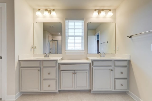 full bathroom featuring double vanity, a stall shower, and a sink