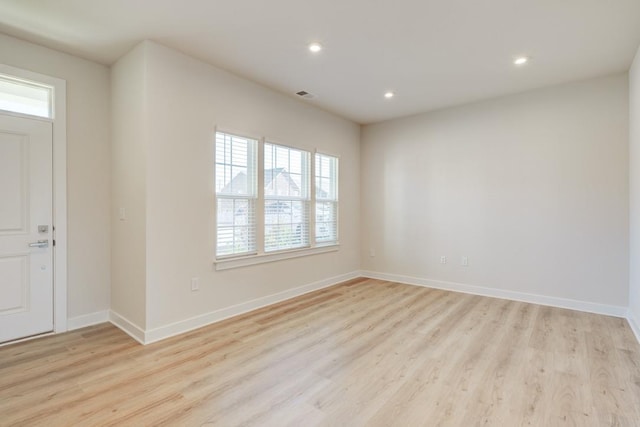 unfurnished room featuring light wood-style floors, visible vents, baseboards, and recessed lighting