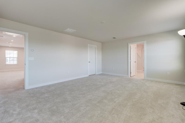 unfurnished room with light carpet and baseboards