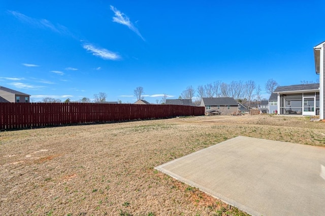 view of yard with a sunroom, fence, and a patio