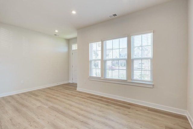 empty room featuring light wood-style flooring, recessed lighting, visible vents, and baseboards