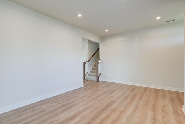 unfurnished room with visible vents, baseboards, light wood-style flooring, stairway, and recessed lighting