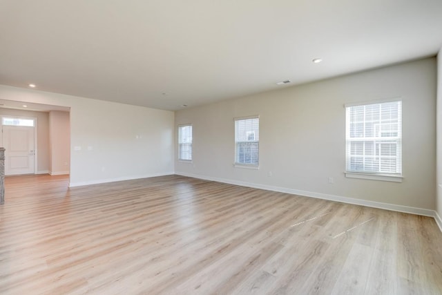 unfurnished room with visible vents, recessed lighting, light wood-style flooring, and baseboards