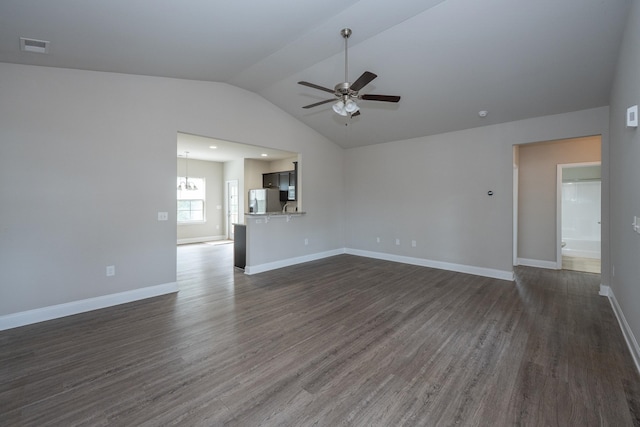 unfurnished living room featuring dark wood-style floors, vaulted ceiling, ceiling fan with notable chandelier, and baseboards