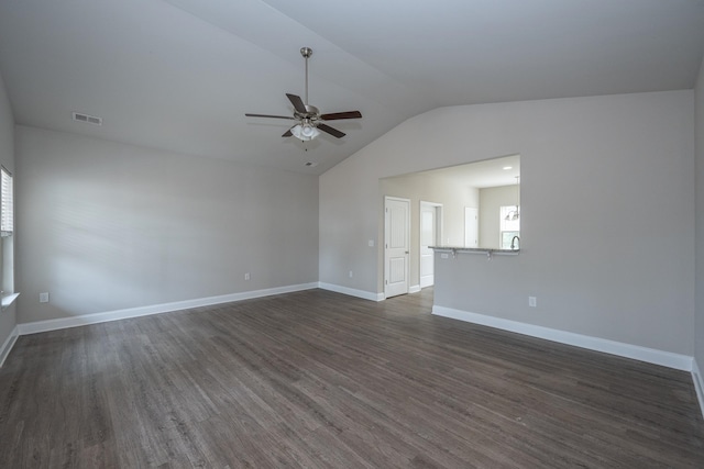 spare room with lofted ceiling, ceiling fan, dark wood-style flooring, visible vents, and baseboards