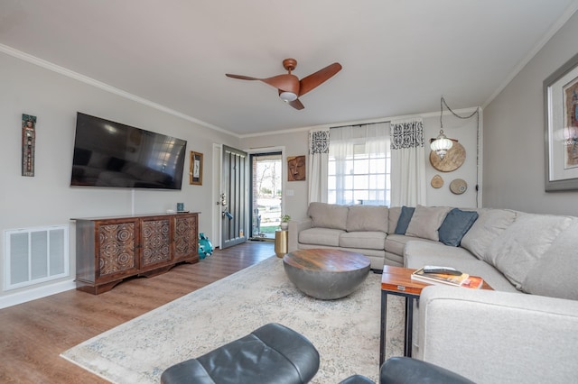 living room featuring ornamental molding, wood finished floors, and visible vents