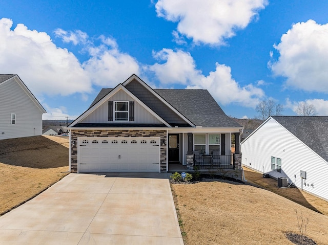 craftsman-style home featuring driveway, stone siding, covered porch, board and batten siding, and a front yard