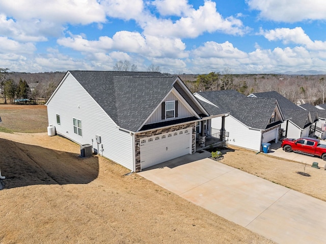 view of front of property with a garage, central AC, a shingled roof, driveway, and board and batten siding