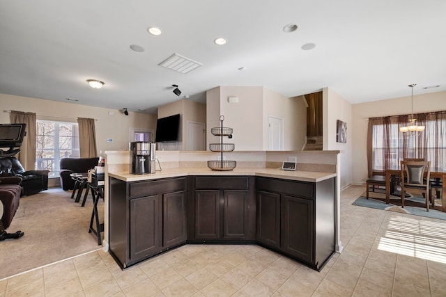 kitchen with light tile patterned floors, a notable chandelier, open floor plan, and light countertops