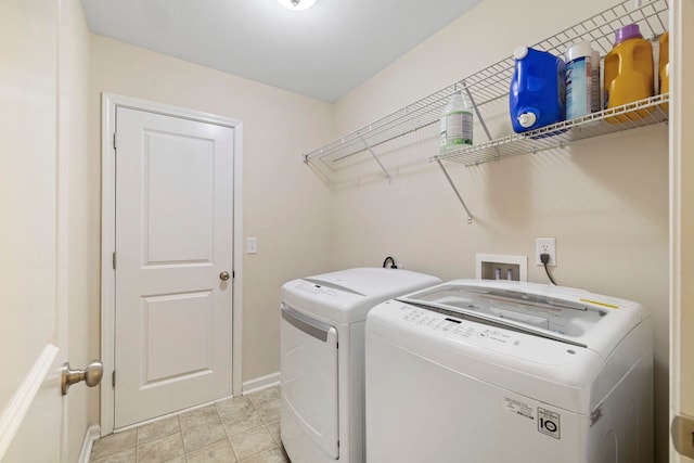 laundry area with laundry area, washing machine and dryer, and baseboards