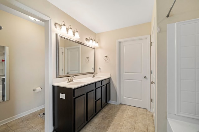 full bathroom featuring double vanity, tile patterned floors, a sink, and baseboards