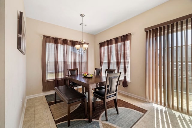 dining space with a notable chandelier, baseboards, and tile patterned floors