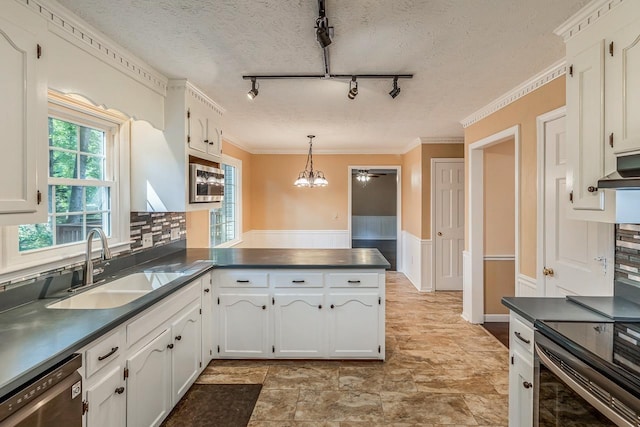 kitchen with stainless steel appliances, dark countertops, a sink, and white cabinets