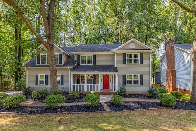 traditional-style house with crawl space, a porch, and roof with shingles