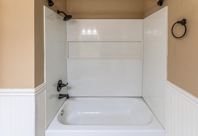 bathroom with wainscoting and shower / tub combination