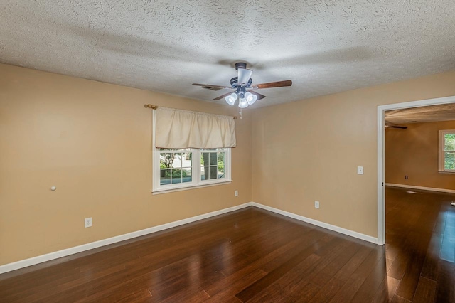 empty room featuring wood-type flooring, baseboards, ceiling fan, and a textured ceiling