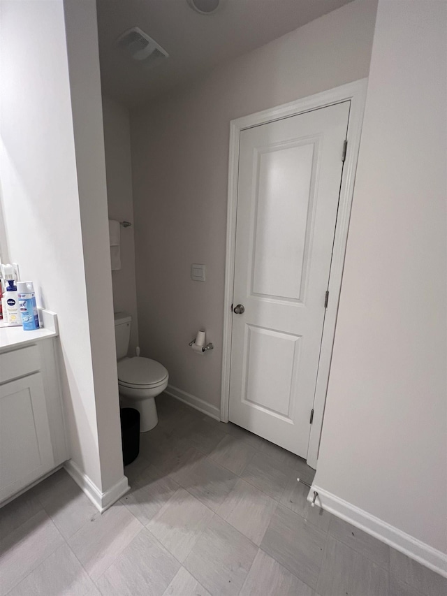 bathroom featuring visible vents, baseboards, toilet, and vanity