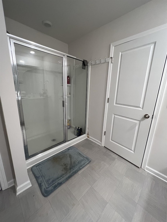 full bathroom featuring a stall shower and baseboards