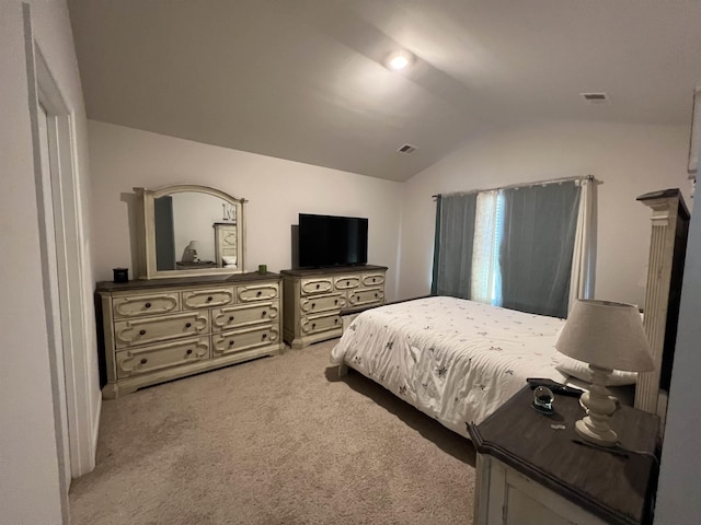 bedroom with vaulted ceiling, carpet flooring, and visible vents