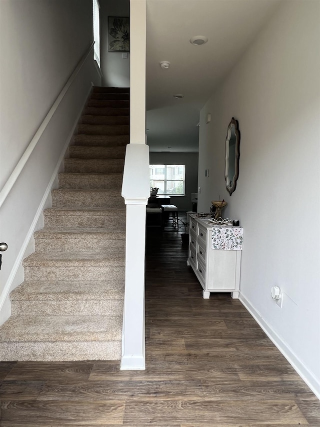 stairway with baseboards and wood finished floors