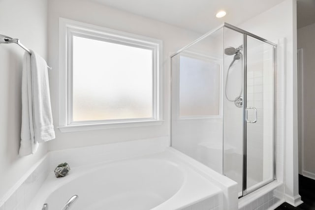 bathroom with a shower stall, a bath, and recessed lighting