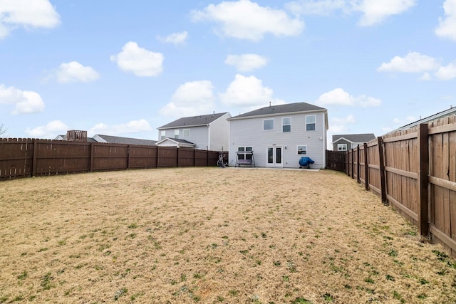 back of property featuring a yard and a fenced backyard