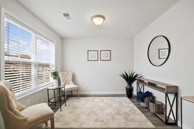 sitting room featuring wood finished floors, visible vents, and baseboards