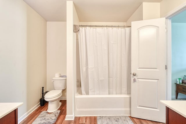 bathroom with shower / bath combo, baseboards, toilet, wood finished floors, and vanity