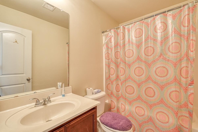 bathroom with toilet, curtained shower, and vanity