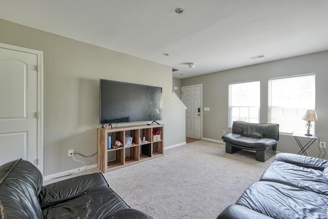 living room featuring carpet, visible vents, and baseboards