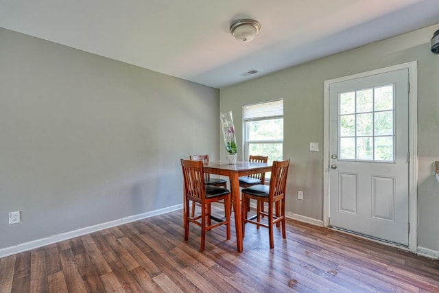 dining area featuring wood finished floors, visible vents, and baseboards