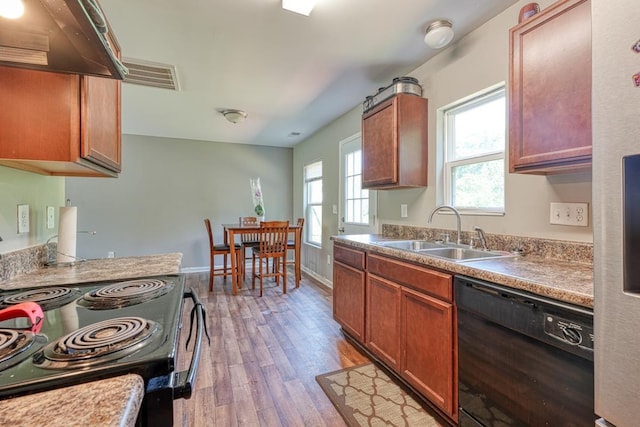 kitchen with visible vents, baseboards, light wood-type flooring, black appliances, and a sink