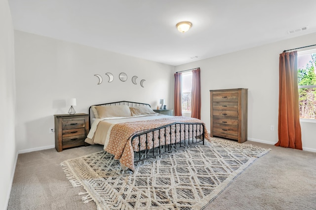 bedroom featuring carpet floors, visible vents, and baseboards